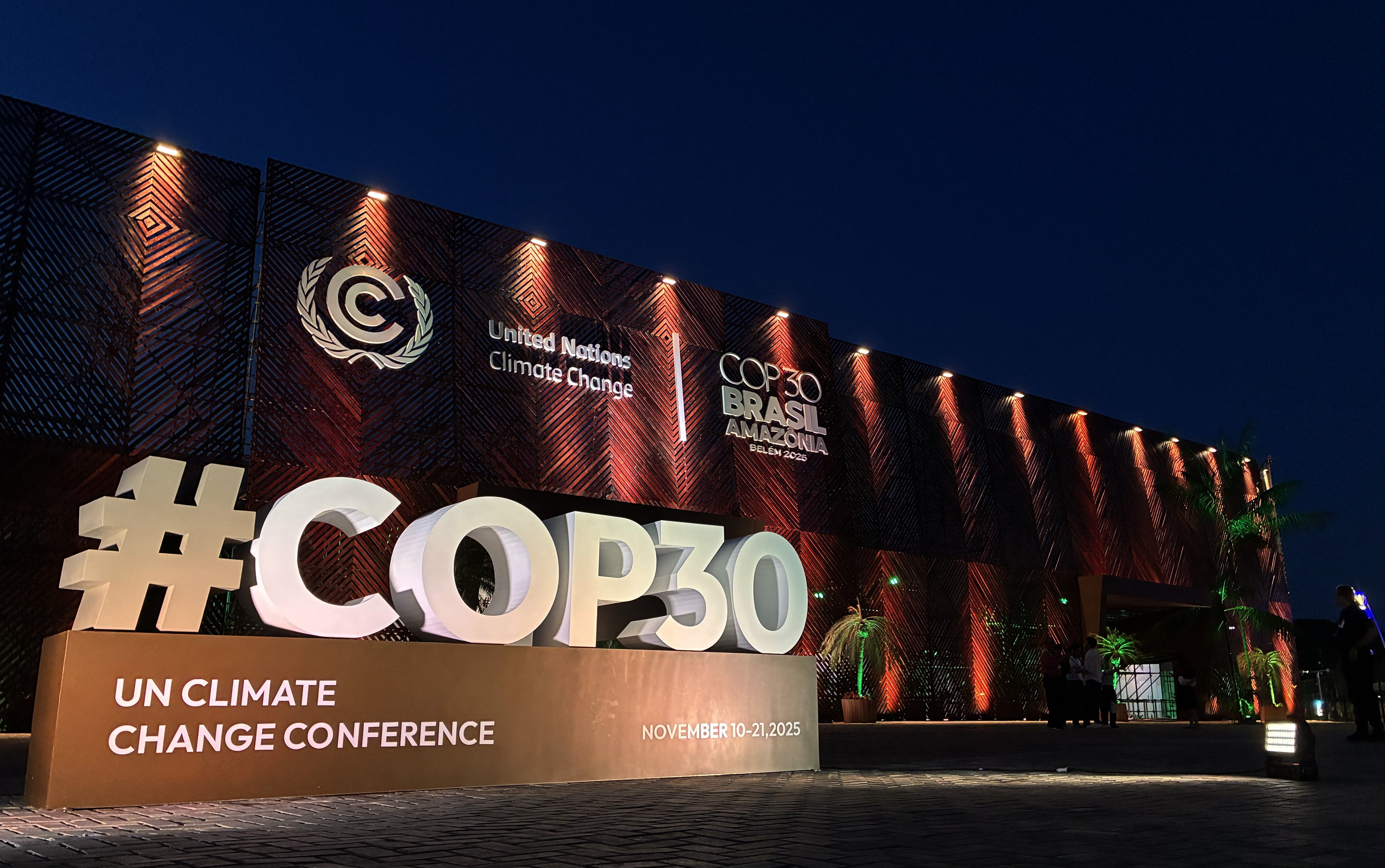 Image of a structure with th hashtag symbol and COP30 outside a building illuminated at night
