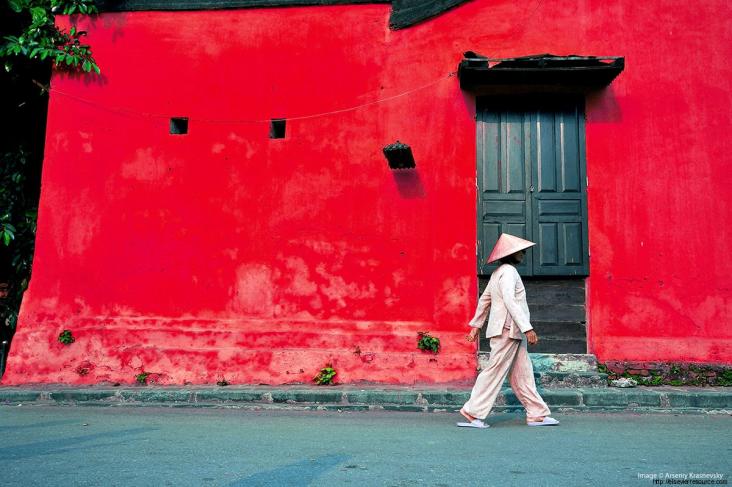 Scene from South-East Asia, woman walking past a building